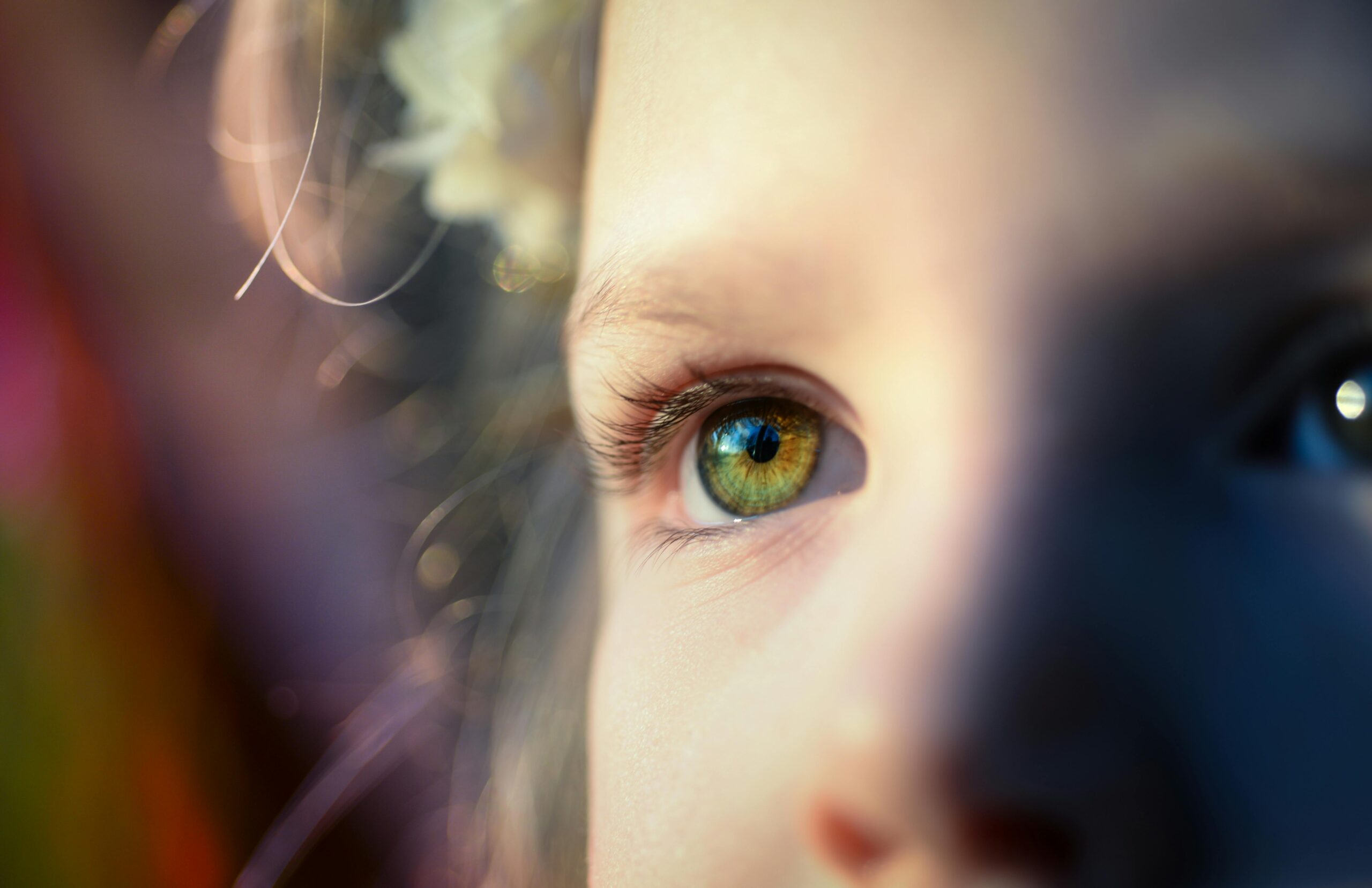 A close-up of a child's eye captures innocence and beauty, enhanced by soft, dreamy light.